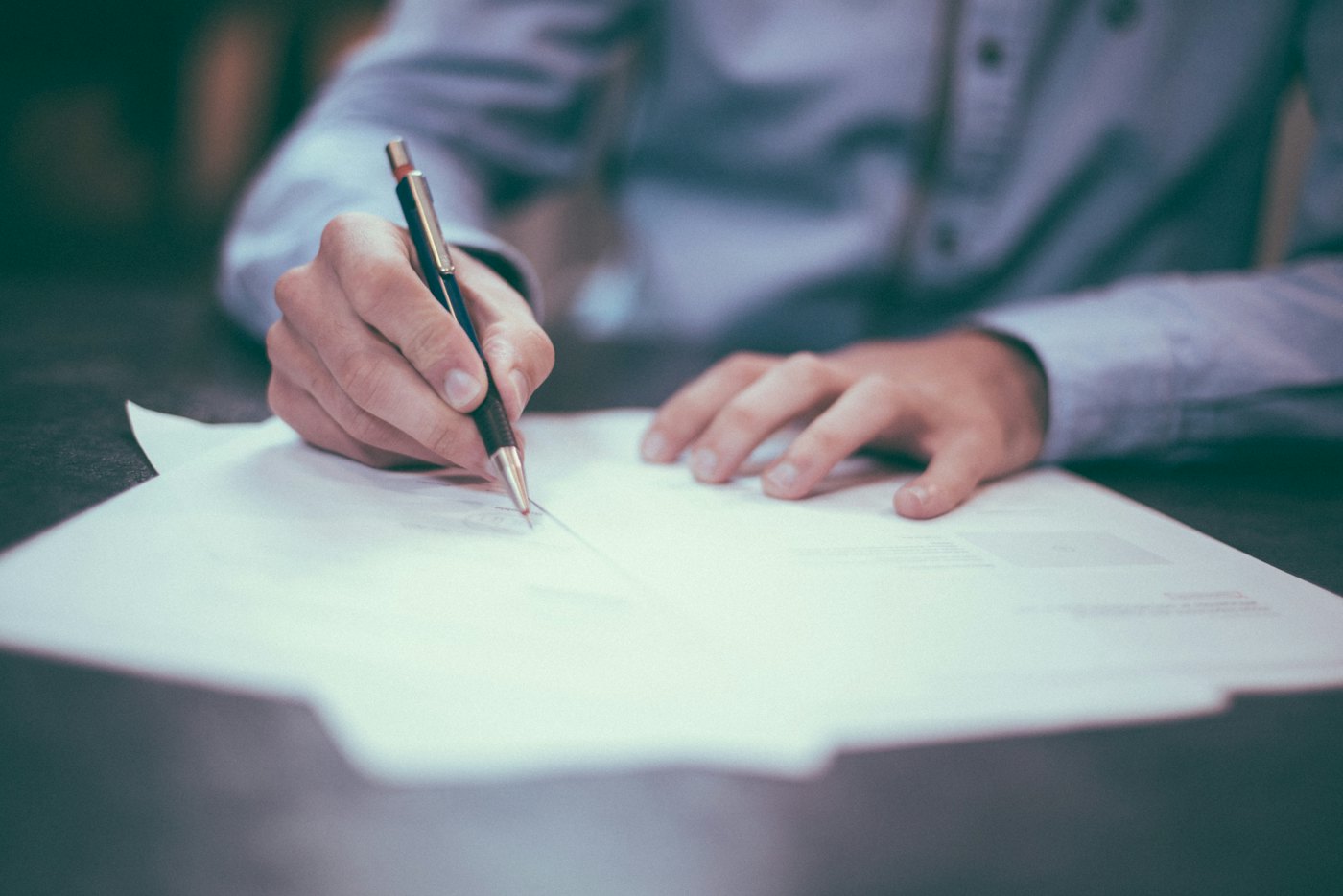 A person reviewing and signing business documents